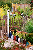 DECORATIVE EDGING USING LIDS FROM COOKING POTS OLD WATERING CAN ROSES DECORATING CHESTNUT PAILING