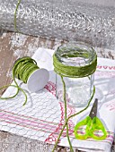 UPCYCLING OLD JAM JARS, CREATING POSIE HOLDER FOR FLOWERS, WRAPPING STRING AROUND JAR.
