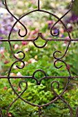 DECORATIVE IRON TRELLIS IN COTTAGE GARDEN