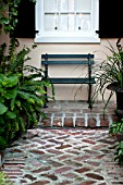 BRICK WALKWAY WITH BENCH IN GARDEN COURTYARD