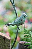 METAL BIRD GARDEN ORNAMENT IN SPRING GARDEN