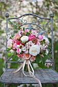 MALUS X EVERESTE  ROSA  RANUNCULUS ASIATICUS IN BOUQUET ON VINTAGE CHAIR