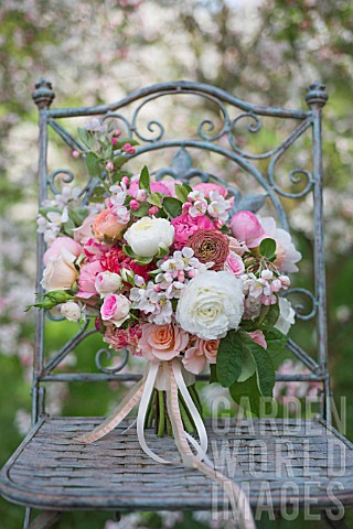 MALUS_X_EVERESTE__ROSA__RANUNCULUS_ASIATICUS_IN_BOUQUET_ON_VINTAGE_CHAIR