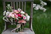 MALUS X EVERESTE  ROSA  RANUNCULUS ASIATICUS IN BOUQUET ON VINTAGE CHAIR