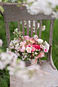 MALUS X EVERESTE  ROSA  RANUNCULUS ASIATICUS IN BOUQUET ON VINTAGE CHAIR