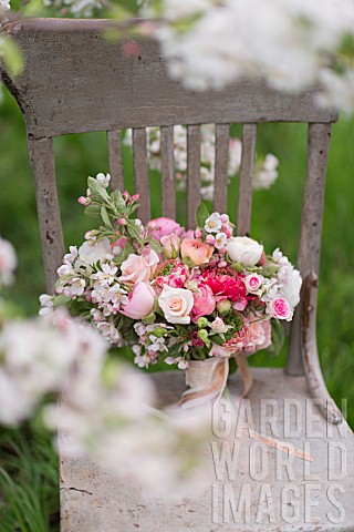 MALUS_X_EVERESTE__ROSA__RANUNCULUS_ASIATICUS_IN_BOUQUET_ON_VINTAGE_CHAIR