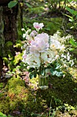 PAEONIA LACTIFLORA, CHESTINE GOUDY AND JAN VAN LEEUWEN PEONIES IN BOUQUET WITH ROSES AND POPPIES IN WOODLAND SETTING