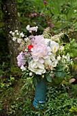 PAEONIA LACTIFLORA, CHESTINE GOUDY AND JAN VAN LEEUWEN PEONIES IN BOUQUET WITH ROSES AND POPPIES IN WOODLAND SETTING