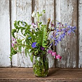 WOODLAND FERNS IN JAR WITH VINCA, BLUEBELLS AND DICENTRA