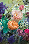 FLORAL ARRANGEMENT OF CUT FLOWERS IN BLUE BOTTLES DETAIL