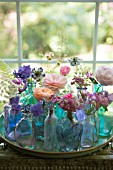 FLORAL ARRANGEMENT OF CUT FLOWERS IN BLUE BOTTLES