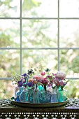 FLORAL ARRANGEMENT OF CUT FLOWERS IN BLUE BOTTLES