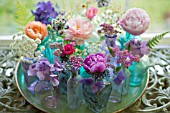 FLORAL ARRANGEMENT OF CUT FLOWERS IN BLUE BOTTLES