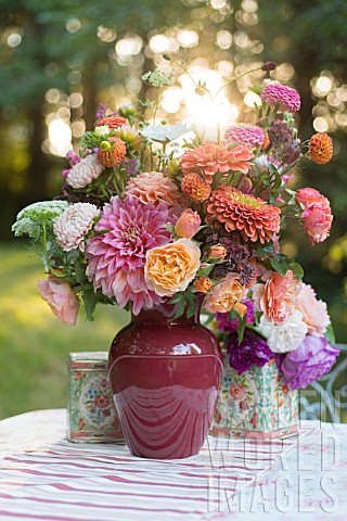 LATE_SUMMER_BOUQUET_OF_DAHLIAS_ROSES_ZINNIAS_ASTERS_ON_OUTDOOR_TABLE