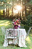 LATE SUMMER BOUQUET OF DAHLIAS, ROSES, ZINNIAS, ASTERS ON OUTDOOR TABLE