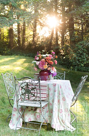 LATE_SUMMER_BOUQUET_OF_DAHLIAS_ROSES_ZINNIAS_ASTERS_ON_OUTDOOR_TABLE