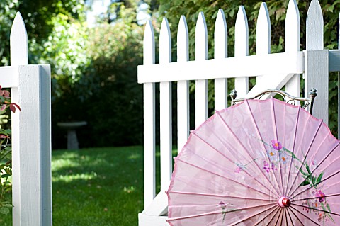 CHINESE_SILK_PARASOL_IN_GARDEN_WITH_WHITE_PICKET_FENCE_AND_GATE