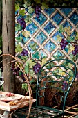 OUTDOOR PATIO GARDEN WITH TRELLIS PERGOLA, QUILT WALL HANGING, TILE AND MOSS FLOOR.