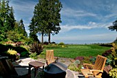 PATIO WITH CHAIRS AND OUTDOOR FIREPLACE IN SEASIDE GARDEN