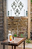 THE DRAWING ROOM GARDEN  URBAN LONDON GARDEN  WATER FEATURE BEHIND CHAIN SCREEN WITH FILIGREE PATTERN WALL PLAQUE  DESIGNED BY: EARTH DESIGNS.