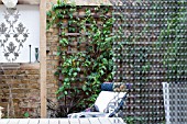 THE DRAWING ROOM GARDEN  URBAN LONDON GARDEN  WATER FEATURE AND CHAIR  FILIGREE PATTERN WALL PLAQUE AND CHAIN SCREEN.  DESIGNED BY: EARTH DESIGNS.