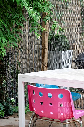 THE_DRAWING_ROOM_GARDEN__URBAN_LONDON_GARDEN__DETAIL_OF_PINK_CHAIR_WITH_CHAIN_SCREEN_AND_JASMINUM__D