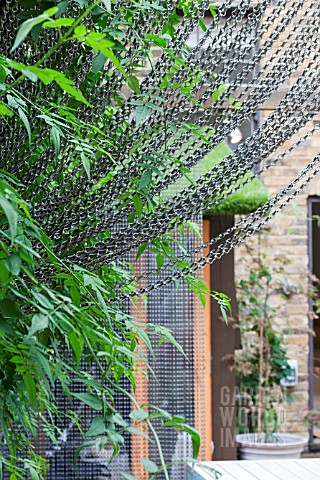 THE_DRAWING_ROOM_GARDEN__URBAN_LONDON_GARDEN__DRAPED_CHAIN_SCREEN_WITH_JASMINUM__DESIGNED_BY_EARTH_D