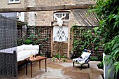 THE DRAWING ROOM GARDEN  URBAN LONDON GARDEN  THE SEATING AREA  WITH THE ILLUMINATED MOOSE HEAD TROPHY AND THE WATER FEATURE  DESIGNED BY: EARTH DESIGNS.