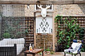 THE DRAWING ROOM GARDEN  URBAN LONDON GARDEN  THE SEATING AREA  WITH THE ILLUMINATED MOOSE HEAD TROPHY AND THE WATER FEATURE  DESIGNED BY: EARTH DESIGNS.