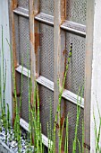 RHS CHELSEA FLOWER SHOW 2013,   THE WASTELAND GARDEN, DESIGNER KATE GOULD.  GOLD MEDAL WINNER  FLATTENED WASHING MACHINE DRUM USED FOR FEATURE ON WALL.