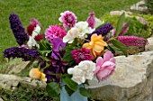 POSY OF CUT GARDEN FLOWERS ON STONE WALL