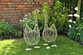 TWO WIRE-FRAMED DECORATIVE GEESE ON GRASS