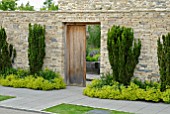 LOOKING THROUGH DOORWAY INTO WALLED KITCHEN GARDEN WITH TAXUS BACCATA AND ALCHEMILLA MOLLIS