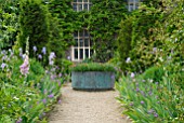 LARGE COPPER PLANTER AND BORDERS WITH IRIS AND ERYSIMUM AT HANHAM COURT