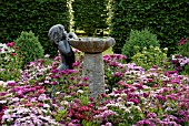 STATUE OF LITTLE GIRL AND WATER FEATURE SURROUNDED BY DIANTHUS BARBATUS (SWEET WILLIAMS)