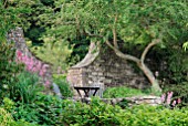 TABLE AND CHAIRS IN COUNTRY GARDEN IN THE COTSWOLDS