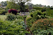 STREAM GARDEN AT OZLEWORTH PARK, GLOUCESTERSHIRE WITH WOODEN BRIDGE