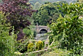 BRIDGE OVER RIVER, VIEWED FROM GARDEN OF IFORD MANOR, WILTSHIRE