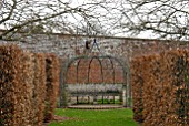 METAL ARBOUR AND STONE SEAT AT OZLEWORTH PARK, GLOUCESTERSHIRE