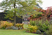 AUTUMNAL VIEW THROUGH YEW HEDGE OF STATUE AND LILY PONDS AT OZLEWORTH PARK, GLOUCESTERSHIRE