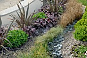 PHORMIUMS, HEUCHERA, BOX AND GRASSES IN SHOW GARDEN AT MALVERN SPRING SHOW 2009, DESIGN BY JULIET STAFFORD