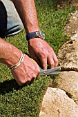 LAYING TURF,  TRIMMING EDGES WITH SCISSORS