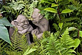 IMP STATUES SITTING IN AMONGST FERNS