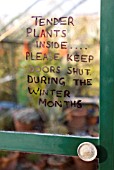 TENDER PLANTS SIGN ON GREENHOUSE DOOR