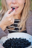 LADY EATING PICKED BLACKBERRY