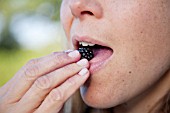 LADY EATING PICKED BLACKBERRY