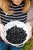 LADY HOLDING BOWL OF BLACKBERRIES