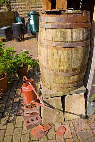 WATER_BUTT_AND_WATERING_CAN_AT_THE_CHELSEA_PHYSIC_GARDEN_WORMERY_AND_COMPOST_BIN_IN_BACKGROUND