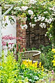 COTTAGE GARDEN SEATING AREA UNDER A TRELLIS ARCH