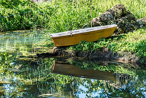 REFLECTION_OF_A_BOAT_AND_GRASSES_ON_A_BOATING_LAKE